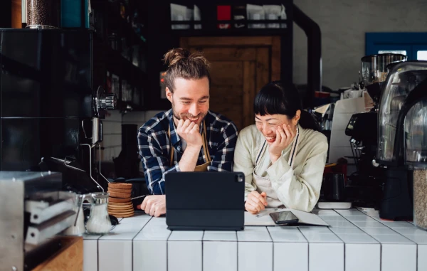 Two people smiling looking at laptop