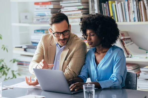 Man and woman at business meeting looking at laptop